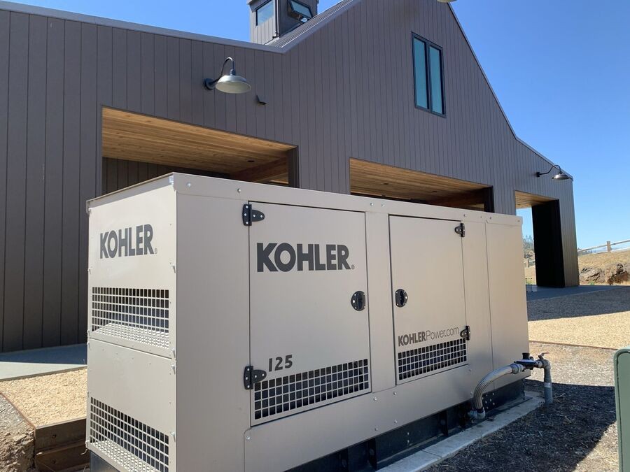 A standby generator installed by the side of a house.