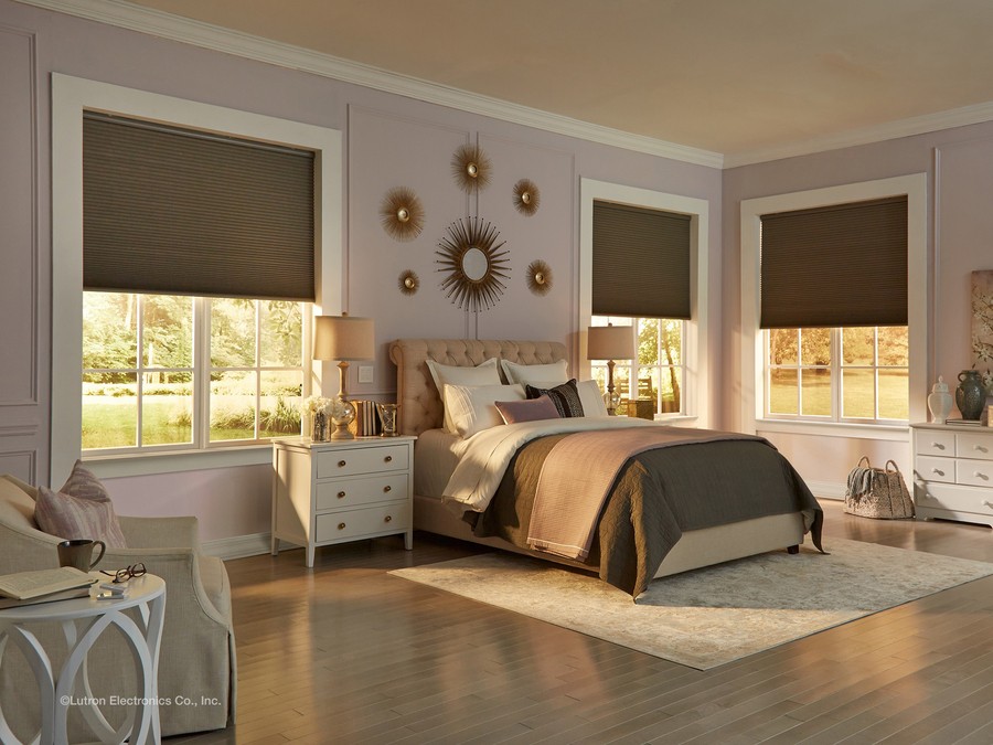An elegant bedroom with Lutron shades halfway down, 