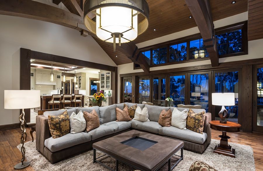 A well-lit living room and kitchen with numerous light fixtures.