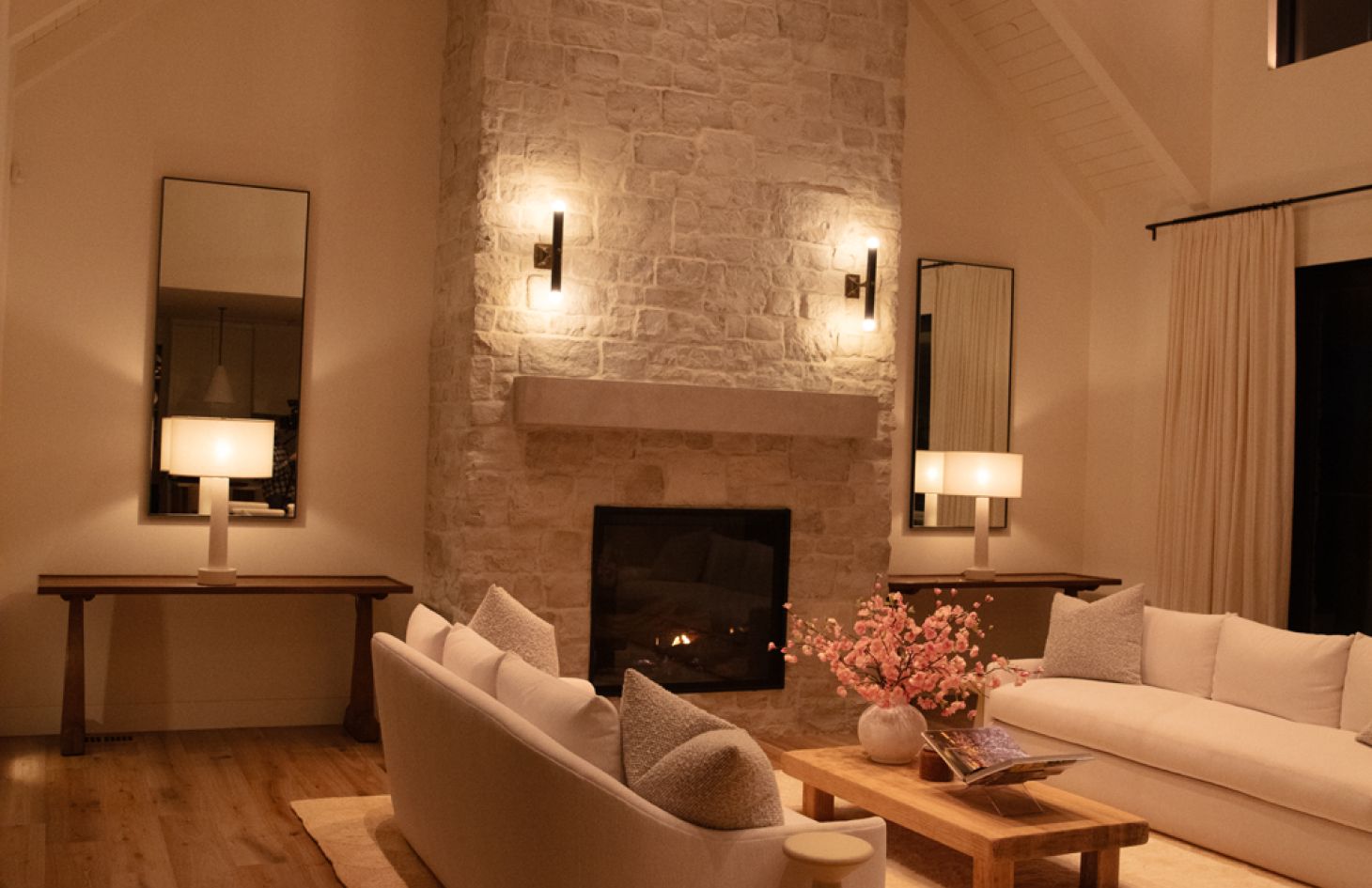 A modern living space with a neutral palette featuring a comfortable sofa, a minimalist coffee table, and expansive windows that fill the room with natural light.